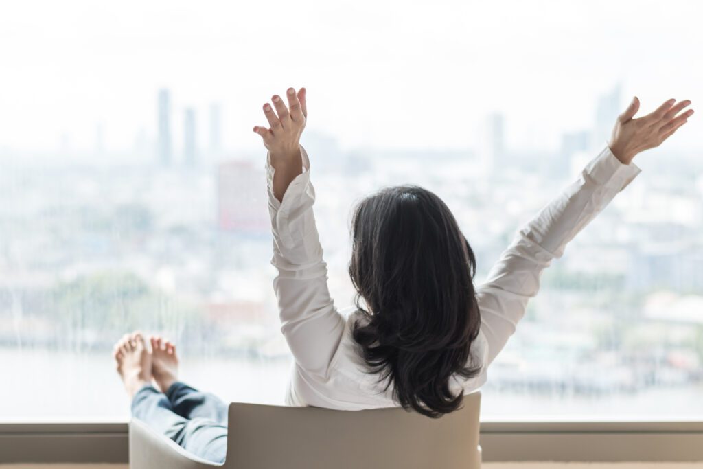 Happy life-work balance of business Asian woman relaxing in hotel living room